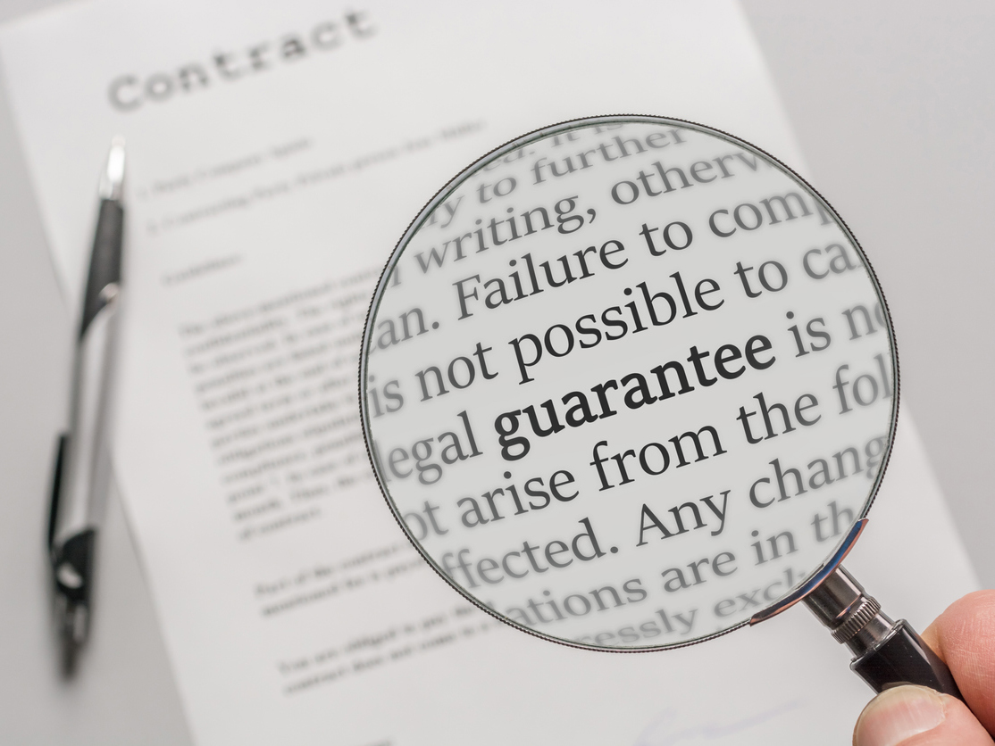 Image of a magnifying glass held over a contract document, highlighting some words.