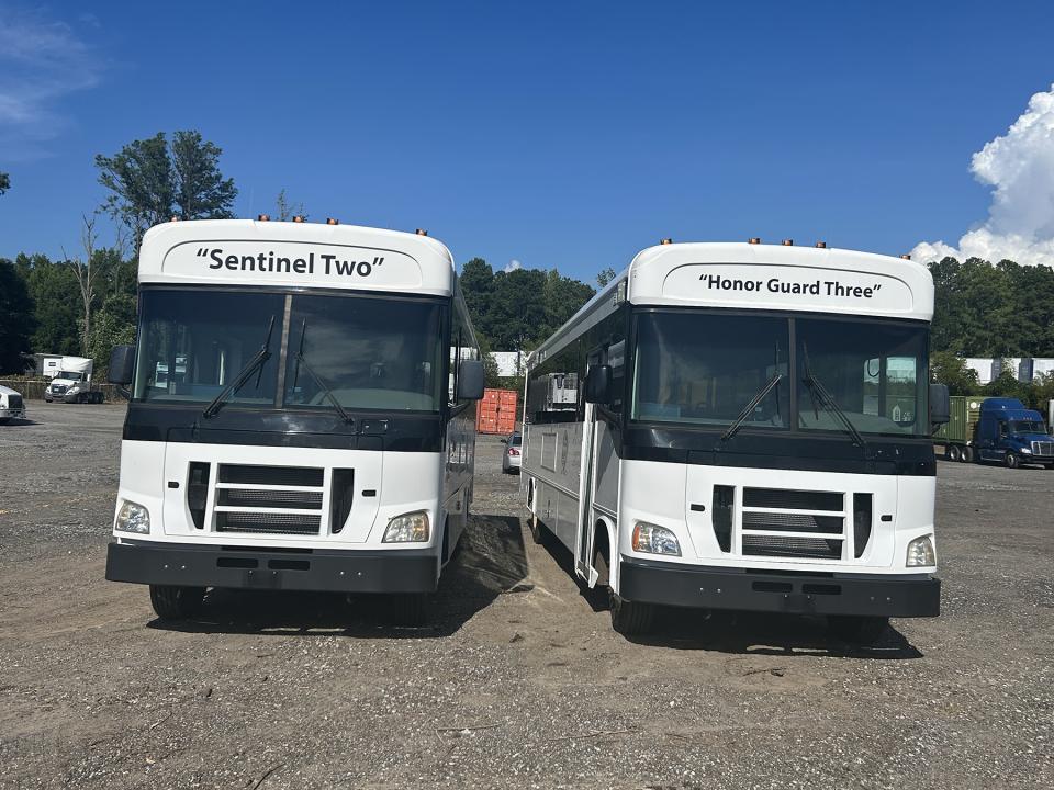 Front view of two ADA vans parked next to each other. Their names -- &quot;Sentinel Two&quot; and &quot;Honor Guard Three&quot; -- are painted on their fronts.