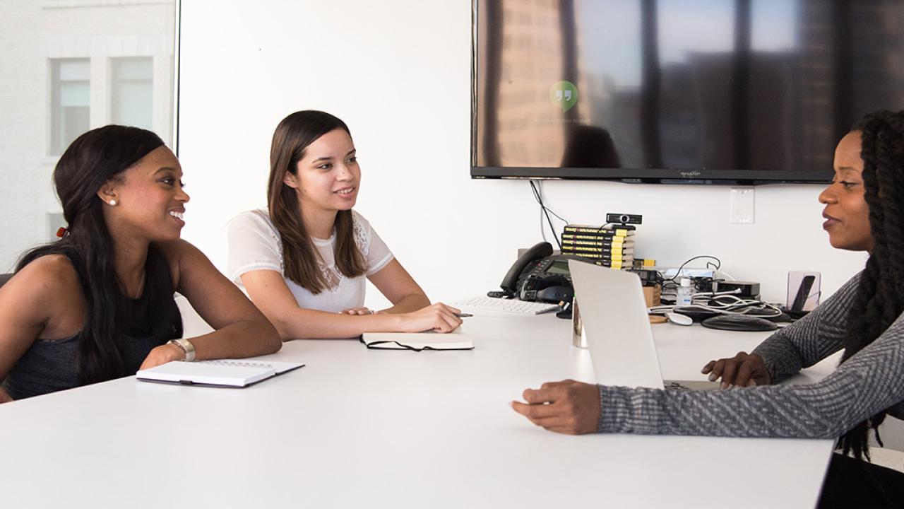 Image of a pair of women sitting across a table from a third woman, who is an HR specialist.