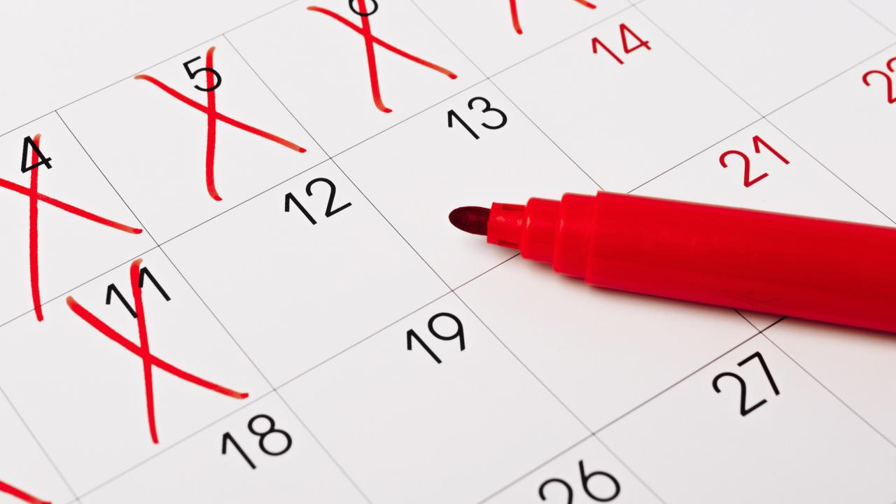 Image of a calendar with dates crossed out through the 11th. A red marker lies across the calender.