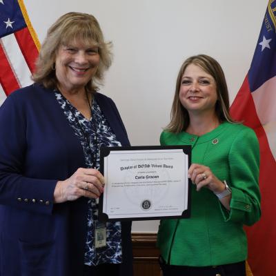 Carla Gracen receives a Display of DOAS Values Award from Commissioner Rebecca Sullivan.