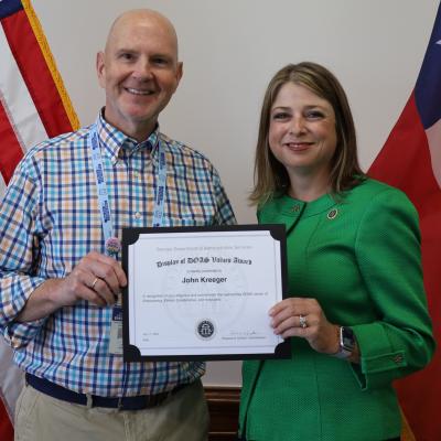 John Kreeger receives a Display of DOAS Values Award from Commissioner Rebecca Sullivan.