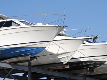 Three boats rest at a drydock facility.