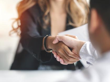 Two people shake hands to conclude a negotiation.