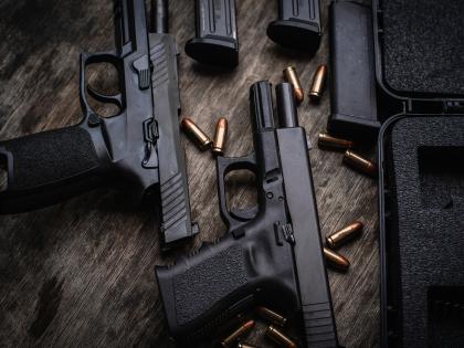 Disassembled pistols rest on a table. 