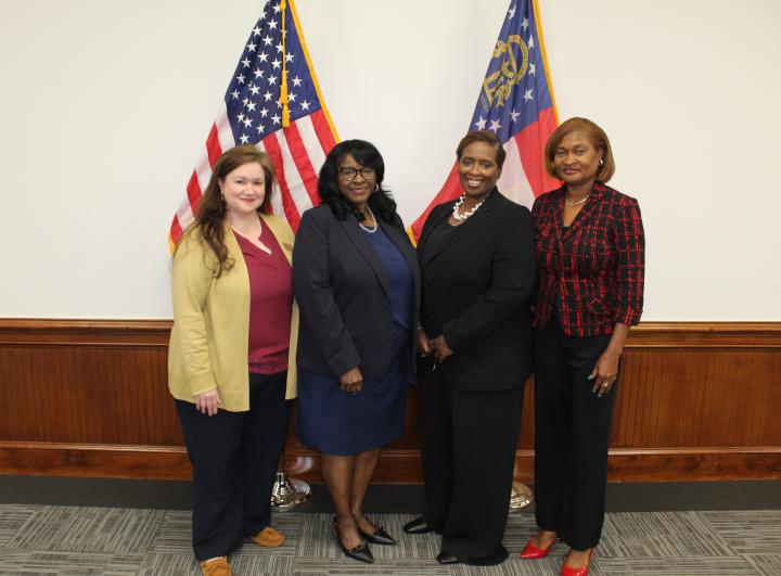 Four Women posing in front of flags