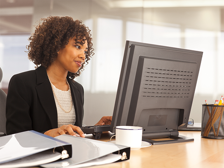 A woman pays attention to her computer screen during a webinar.