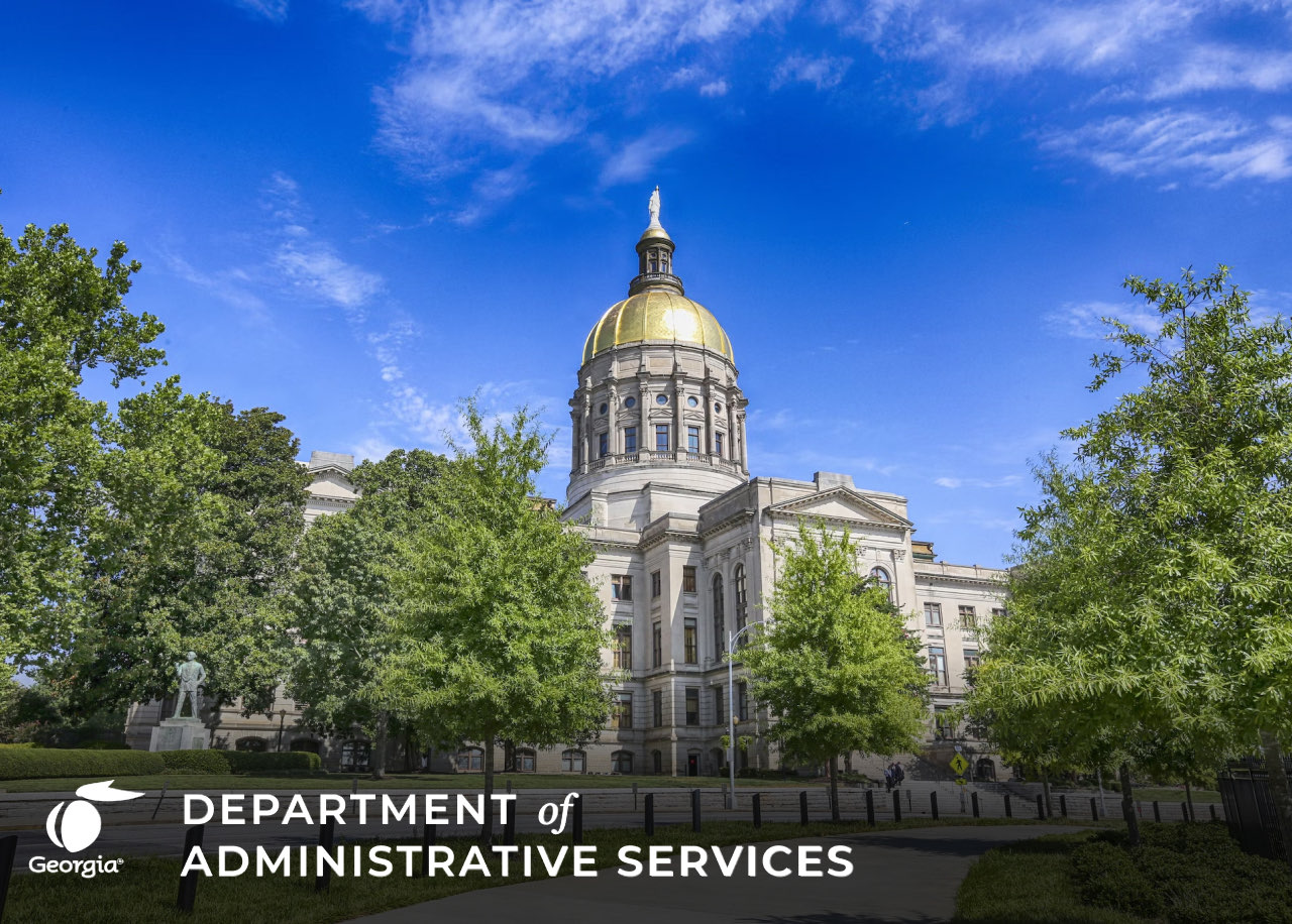 Photograph of the Georgia state capitol building. There are large trees in front of the photo and blue skies with a few wispy clouds behind the building. The wording `Department of Administrative Services` is overlaid in the bottom left corner of the photo accompanied by the Georgia state logo.