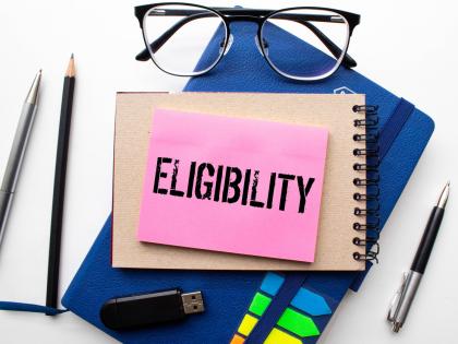 Image of a pile of office supplies with a note atop them that reads, "ELIGIBILITY."