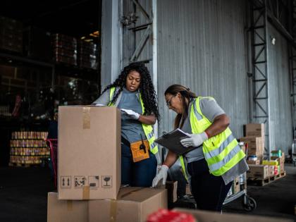 Two workers exam a delivery of returned items.